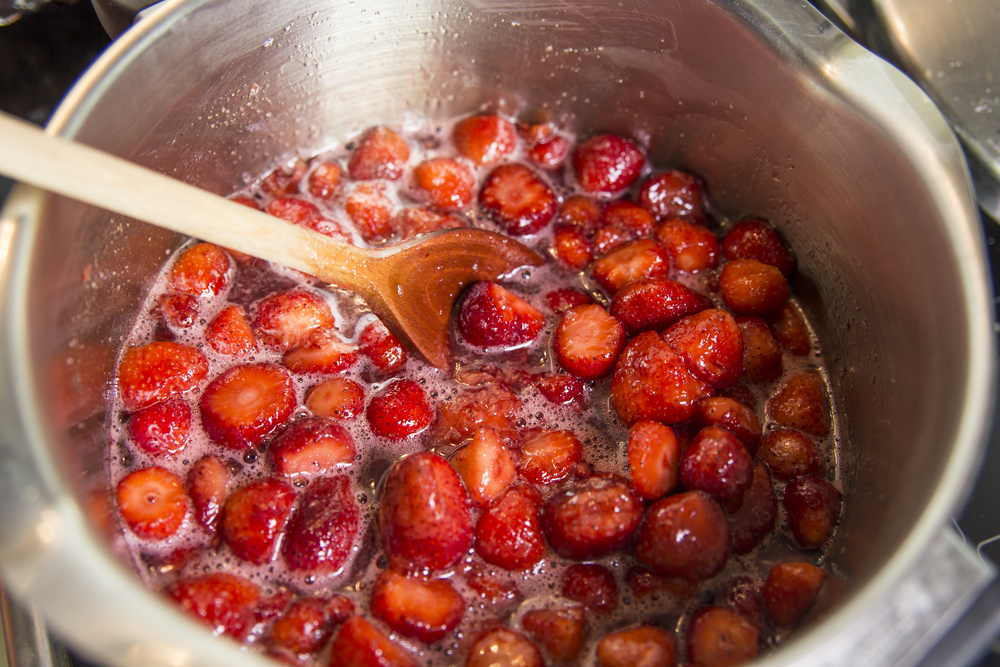 Simmering strawberries to make strawberry jam at home