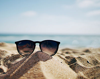 Sonnenbrille im Sand