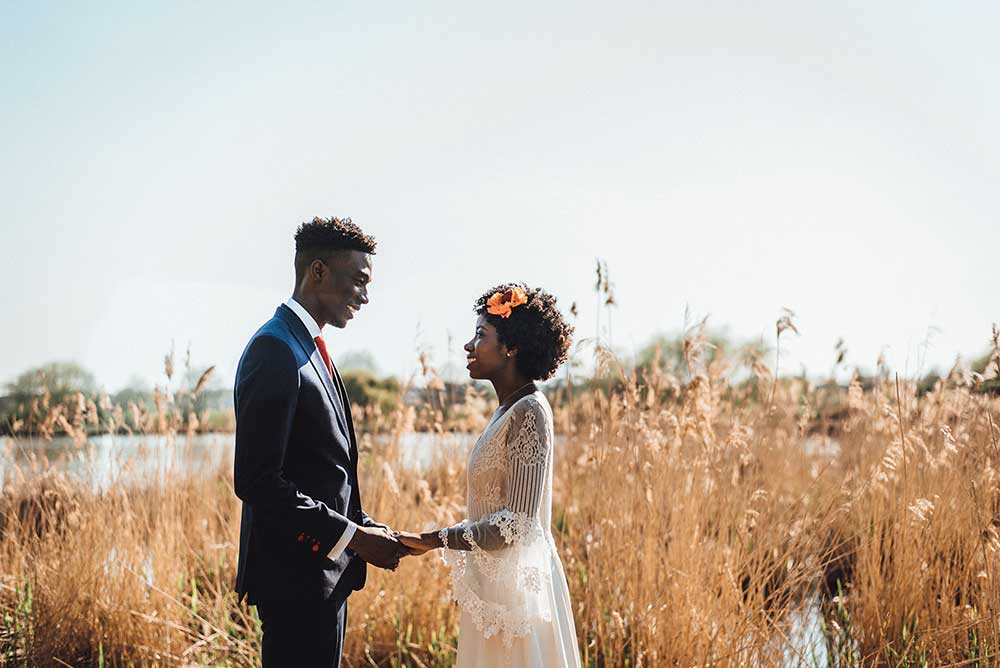 Bride and groom eloping in a field on their wedding day
