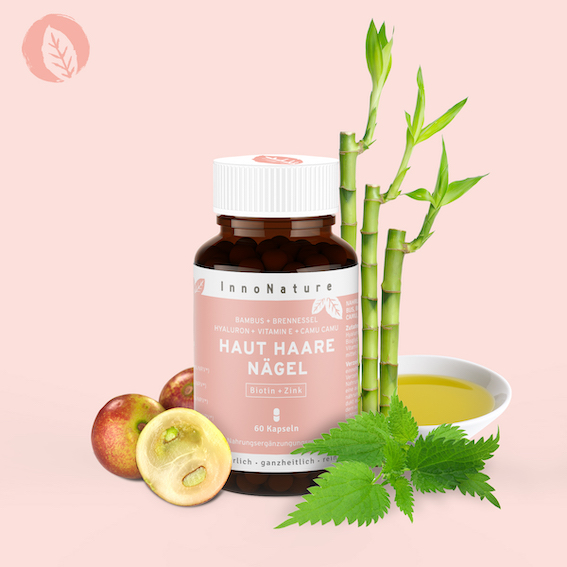 dose-haut-haare-naegel-kapseln-von-innonature-vor-rosa-hintergrund-bambus-und-brennnessel-hinter-der-dose