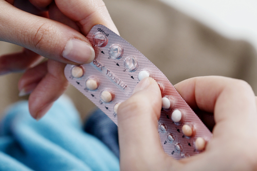 frauenhand-drueckt-pille-aus-anti-baby-pillen-packung