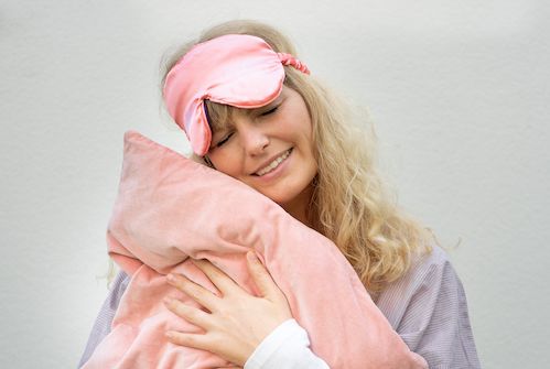 Julia hält sich ihr rosa Kissen an die Backe