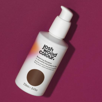 A bottle of brown hair colour on a pink background - Josh Wood Hair Colour Expert