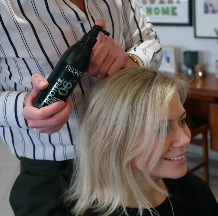 A woman is getting her hair washed by a man in a salon - Josh Wood Hair Colour Expert