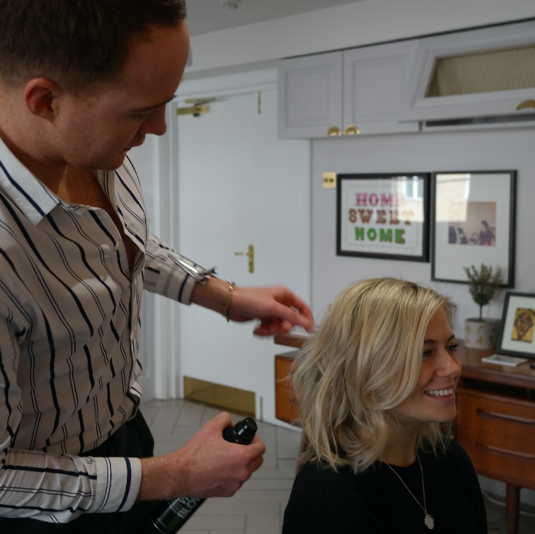 A man is combing a woman's hair - Josh Wood Hair Colour Expert