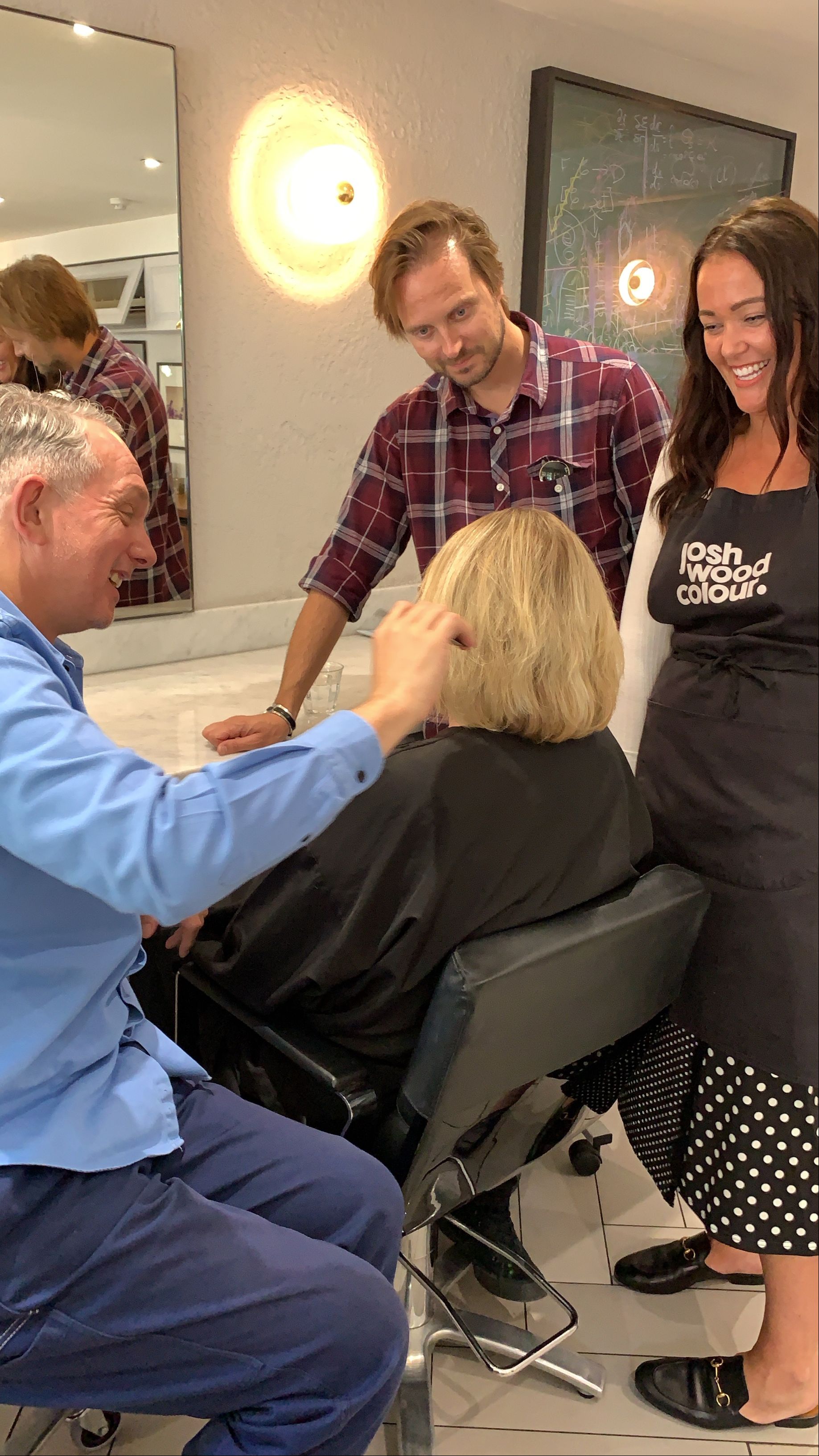 A group of people sitting in a salon with a hairdresser - Josh Wood Hair Colour Expert