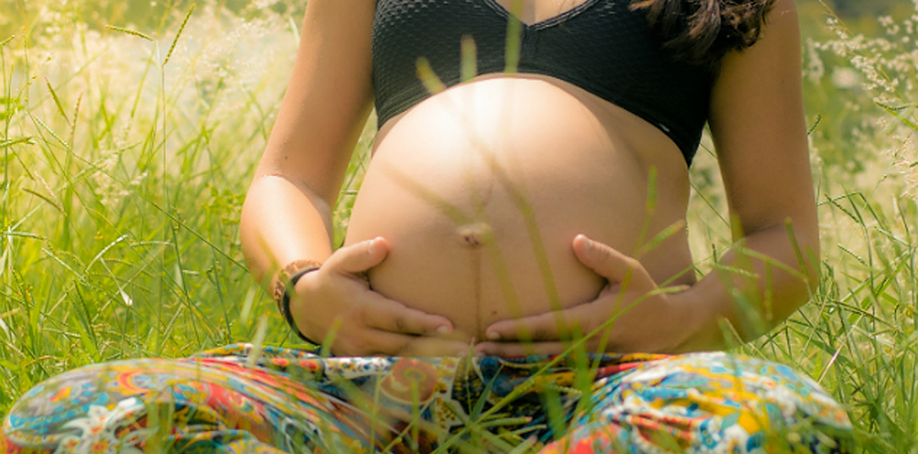Pregnant woman meditating in field