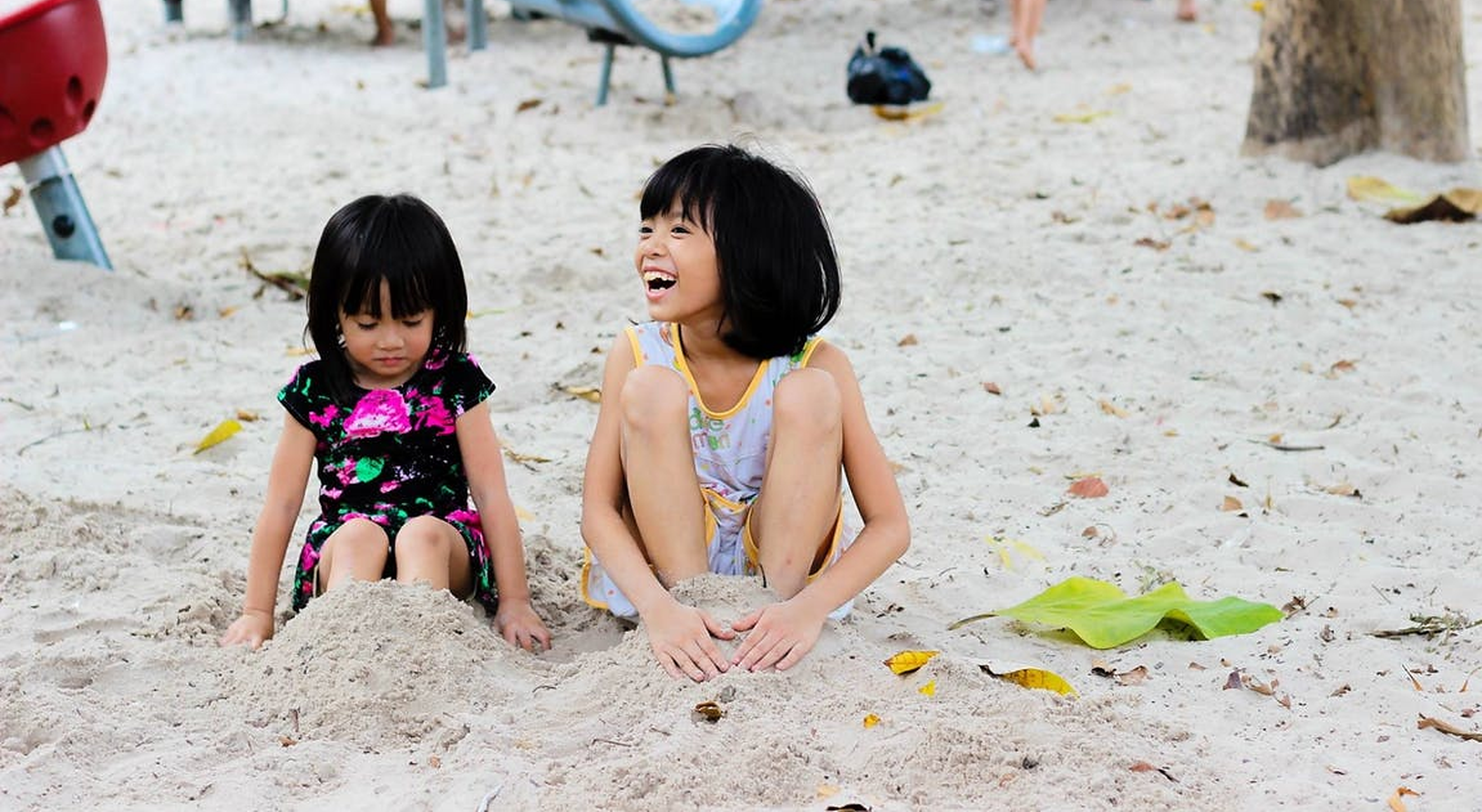 Two children playing on the beach in the sun