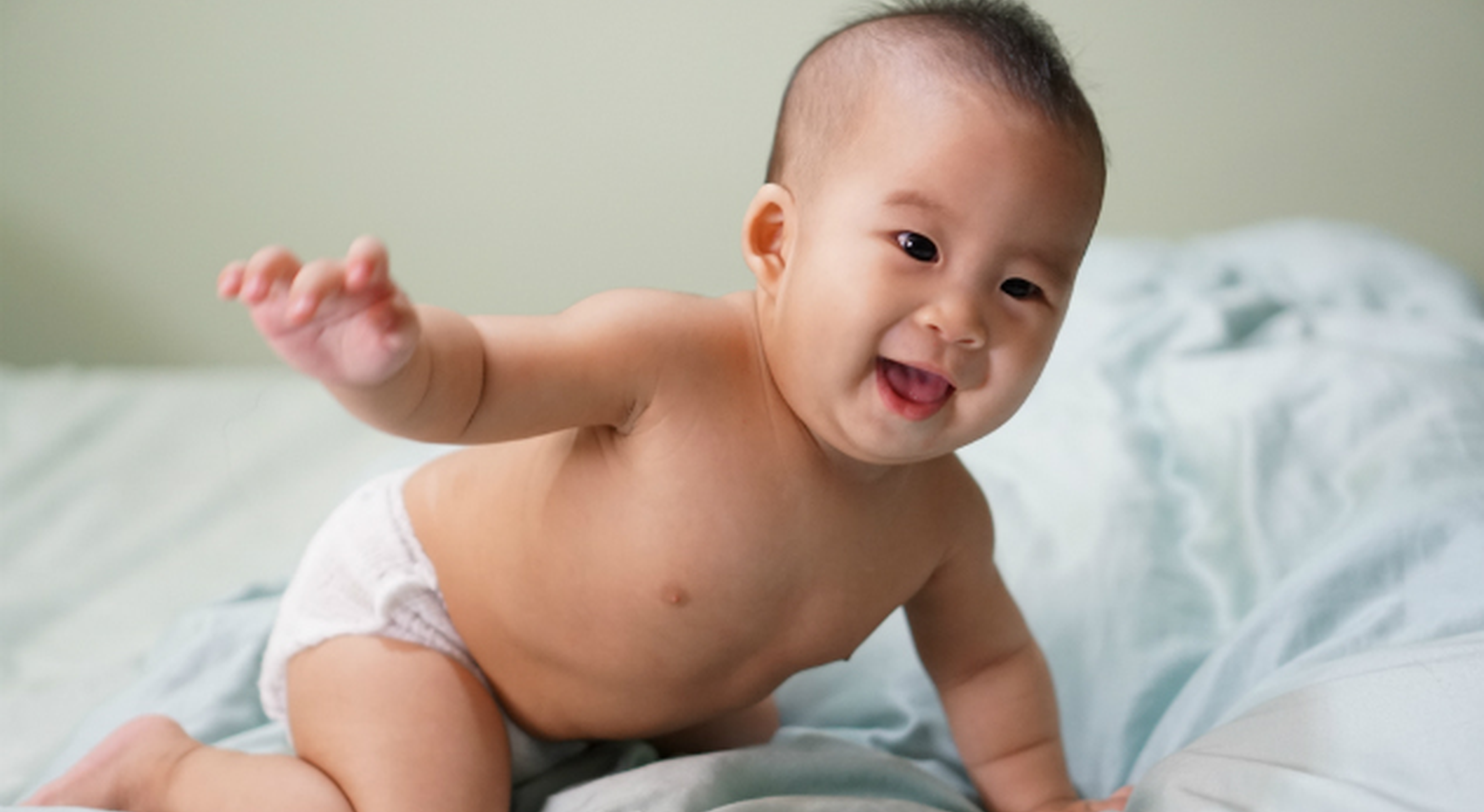 baby in diaper on bed