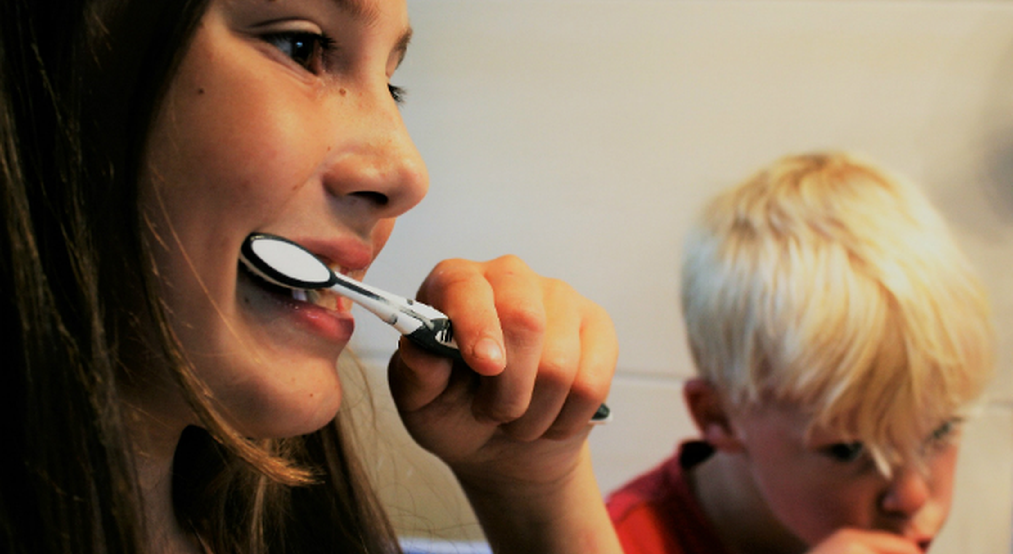 Two children brushing their teeth together