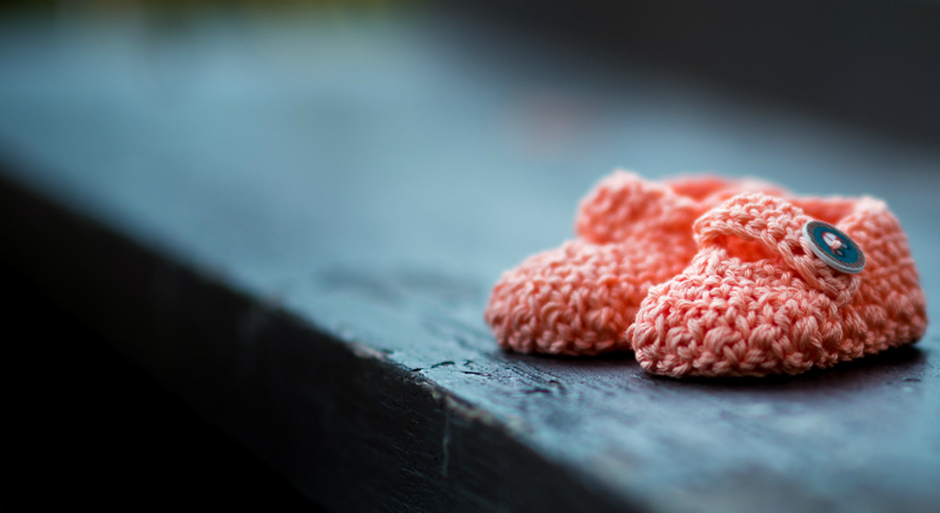 Pink newborn shoes sat on a bench