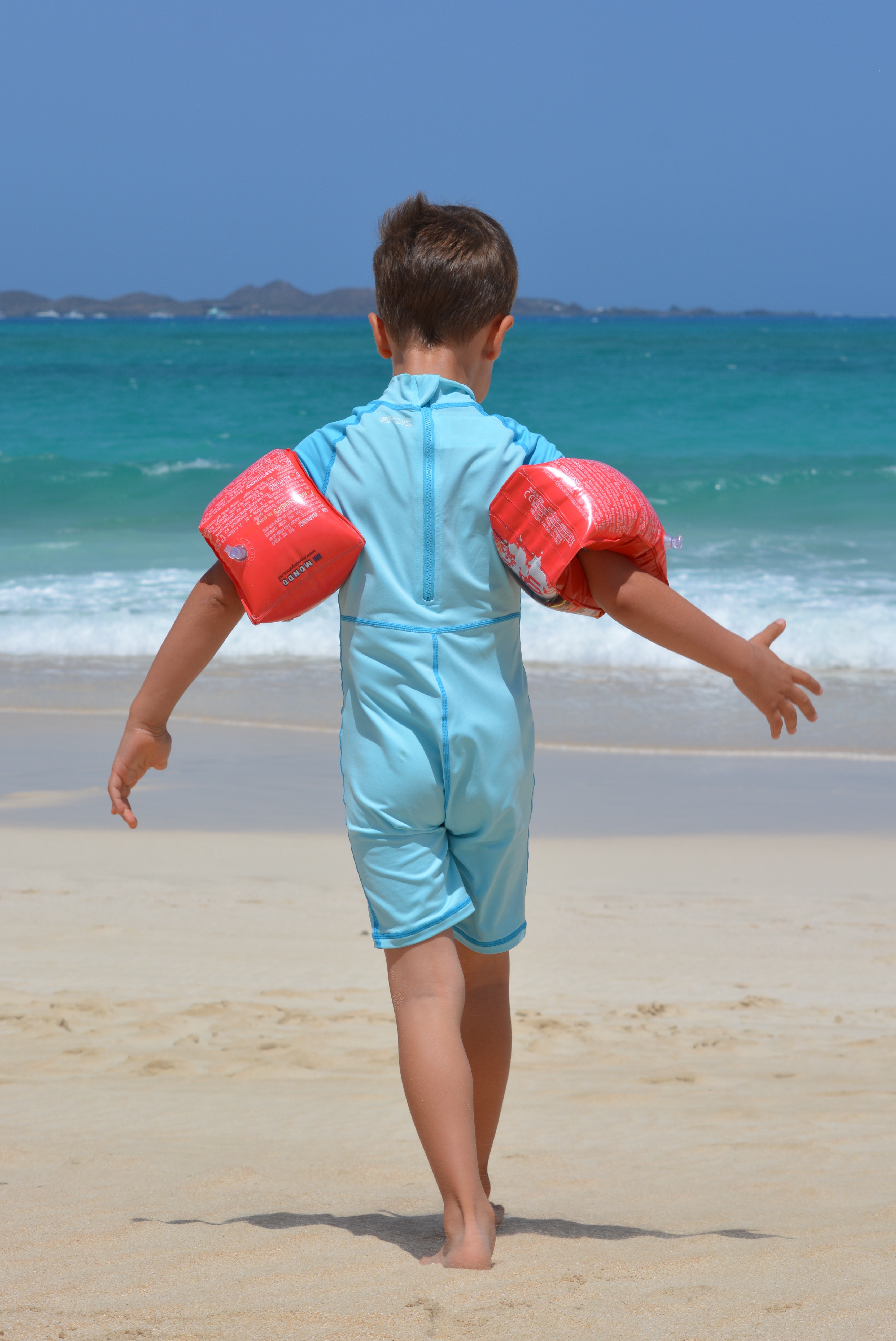 Boy with armbands on the beach
