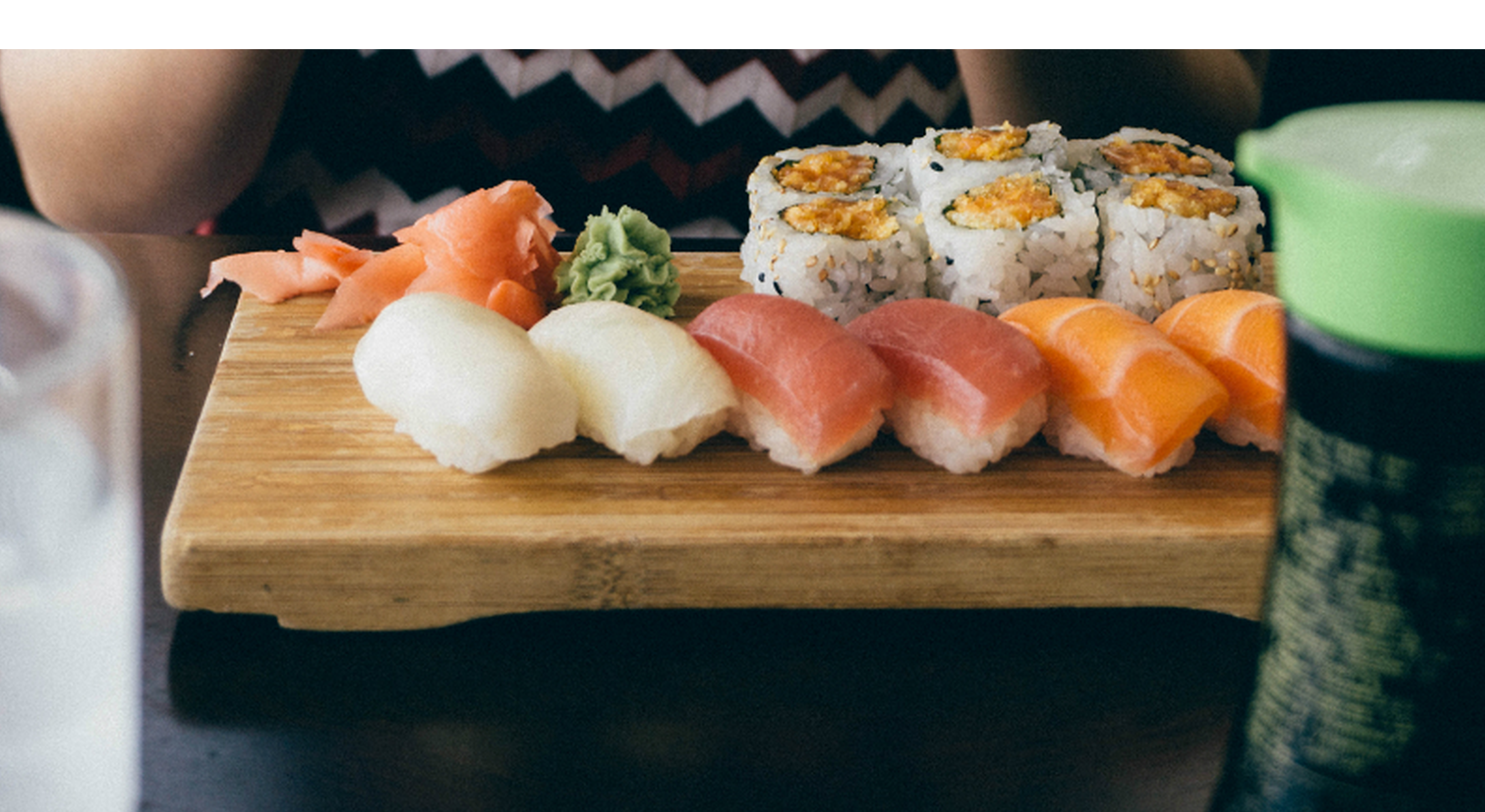 Person eating platter of sushi in a restaurant