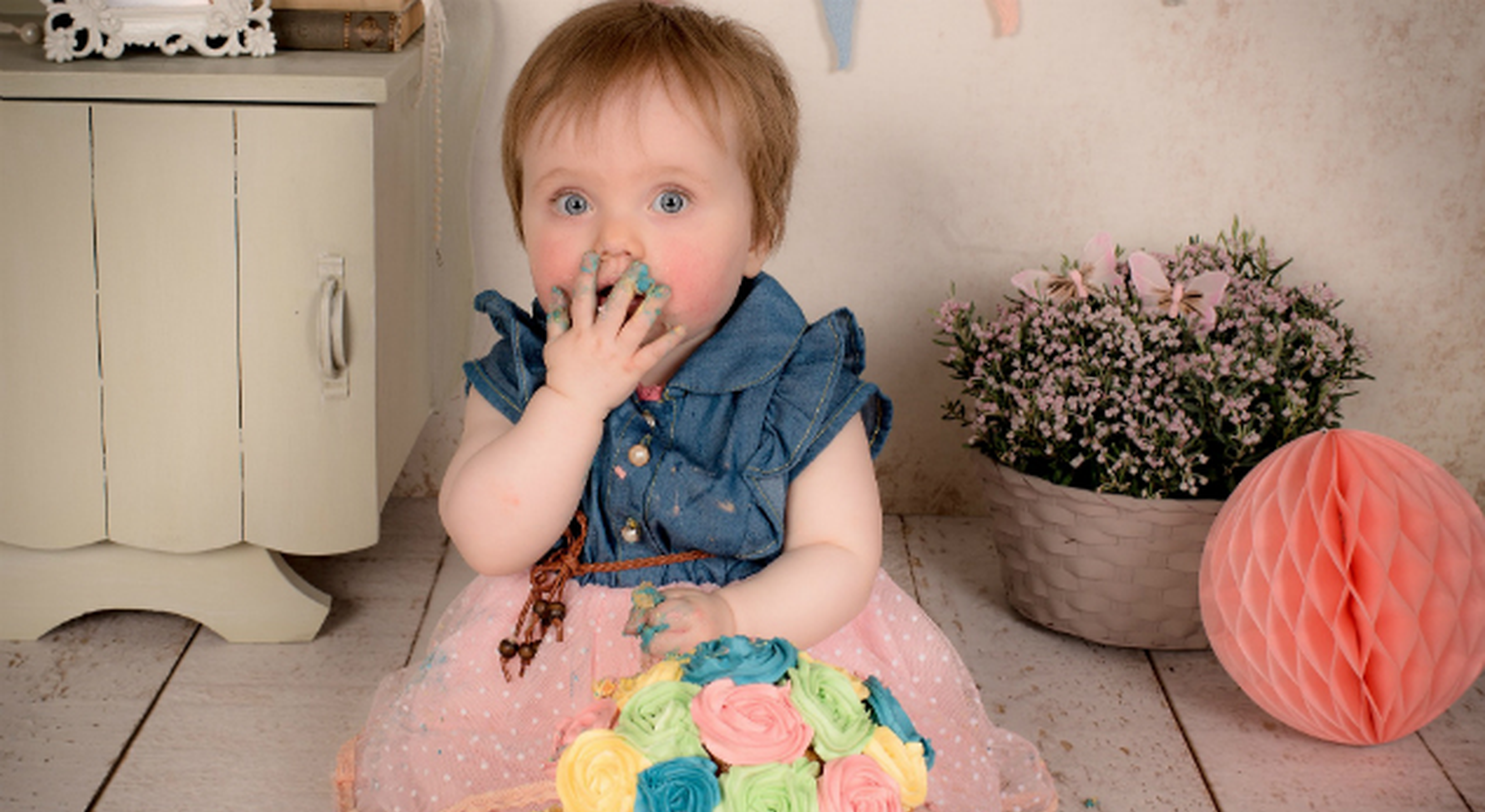 Blue eyes toddler girl eating sweets with dirty hands
