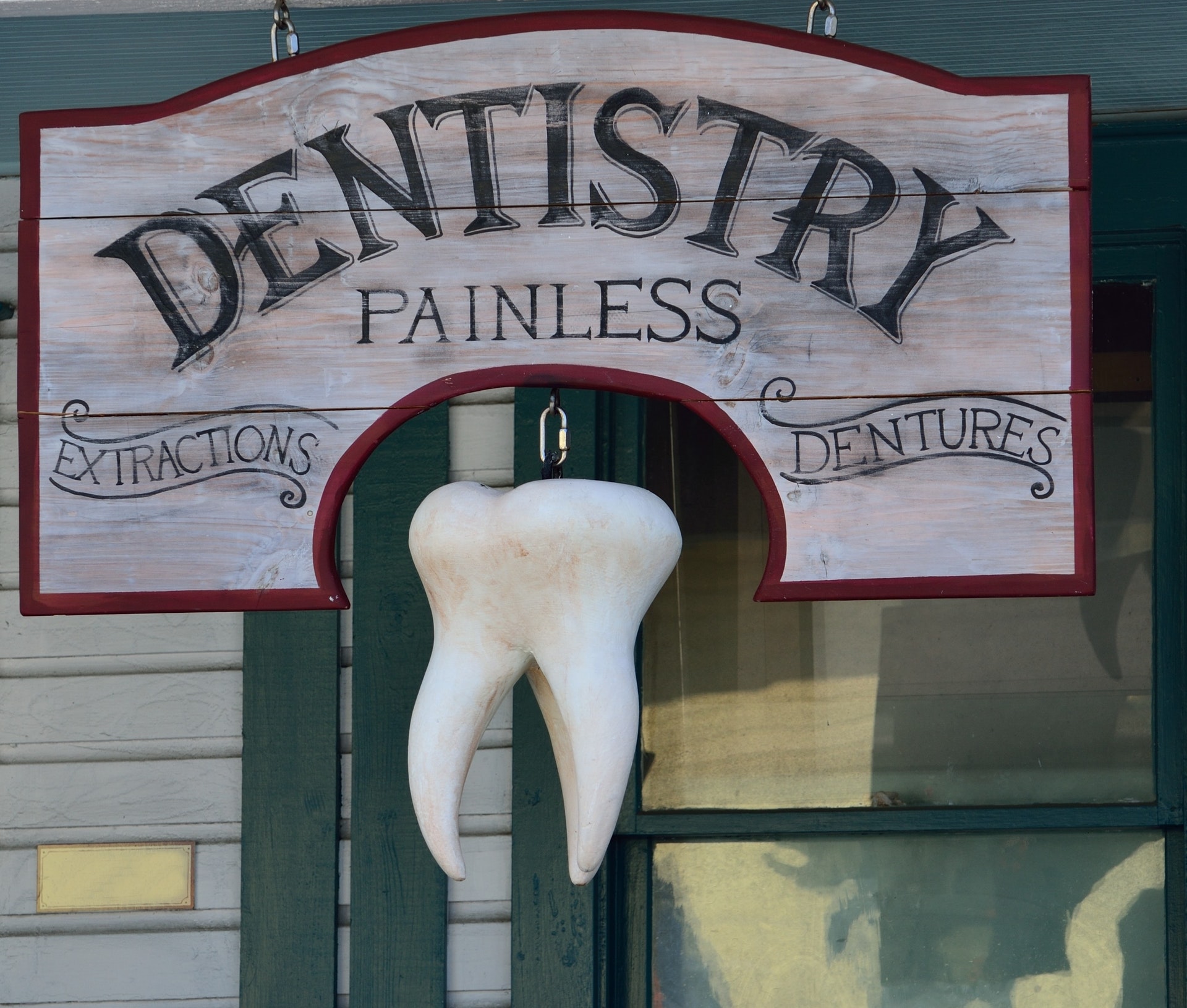 Dentist sign advertising painless procedures