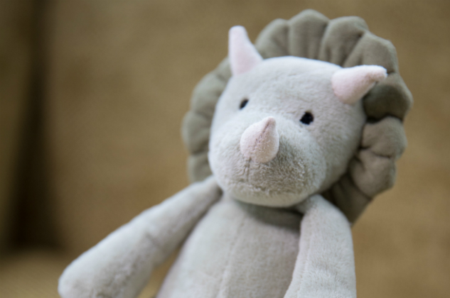 A stuffed rhinoceros plush sits on a chair
