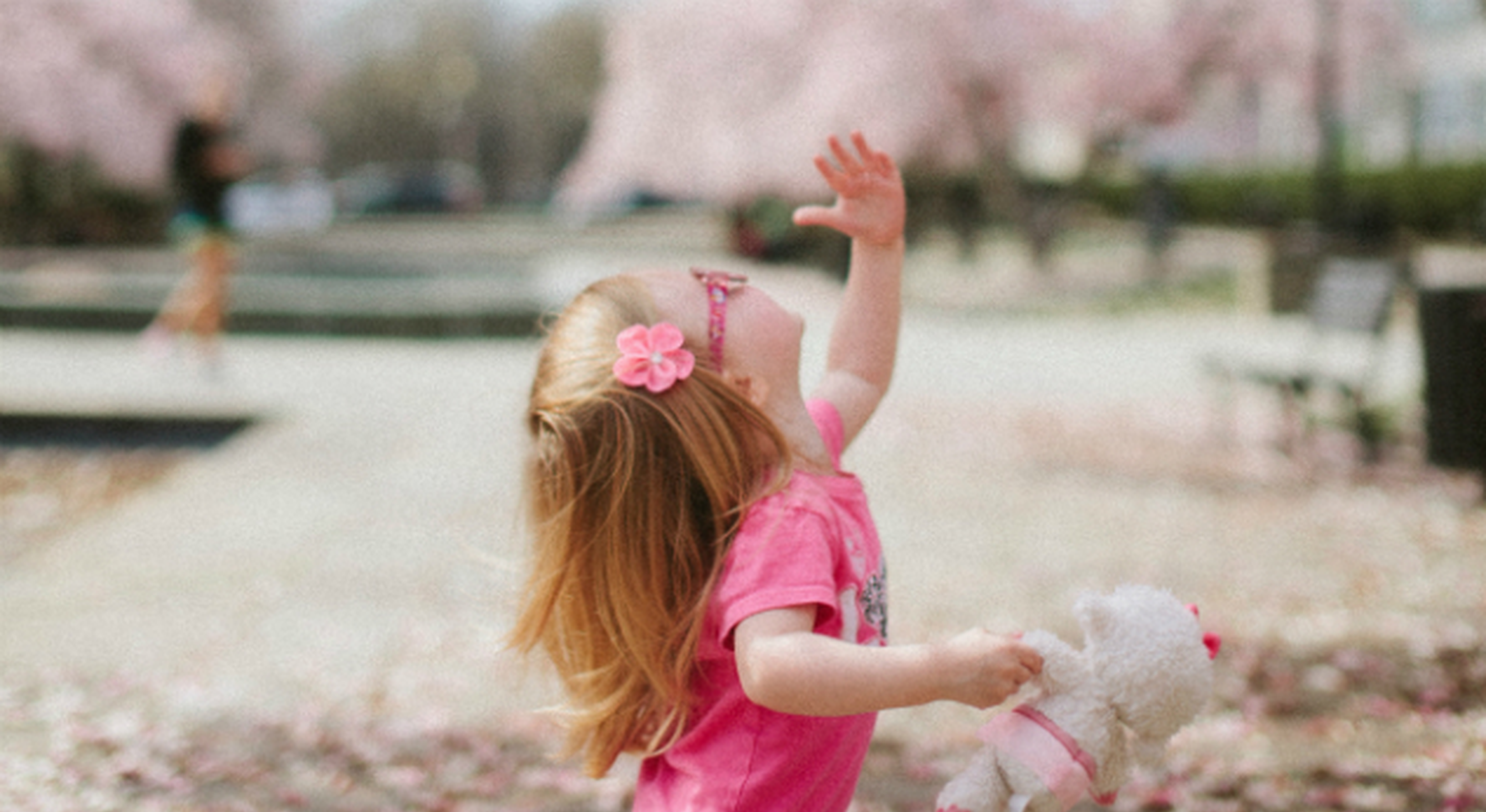Young girl in glasses surrounded by tree blossom
