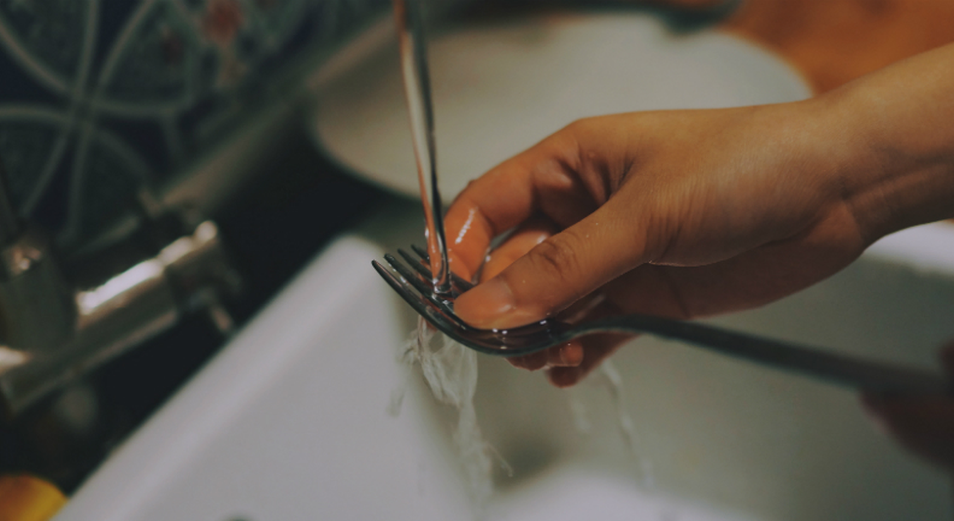 washing fork under running tap water