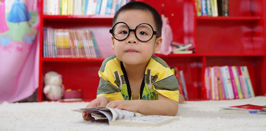 Little boy wearing glasses reading