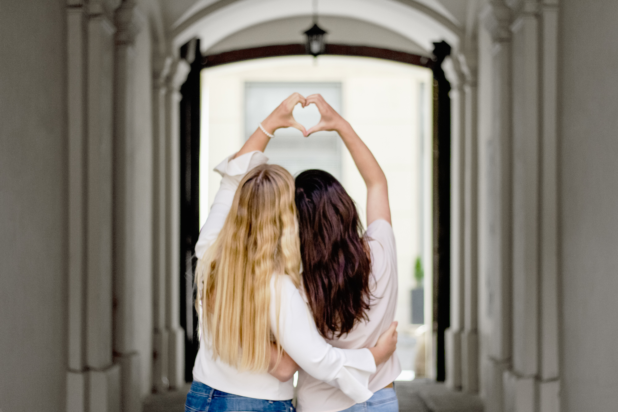 two women hugging, women supporting women, women forming hearts with their hands, blonde and brunette women